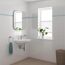 Waschbecken mit Armatur, Spiegel, Handtuch und Pflanze