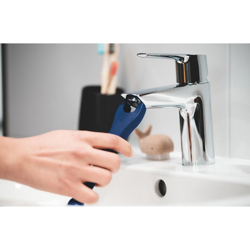 Person hält einen blauen Wasserhahn-Schlüssel.