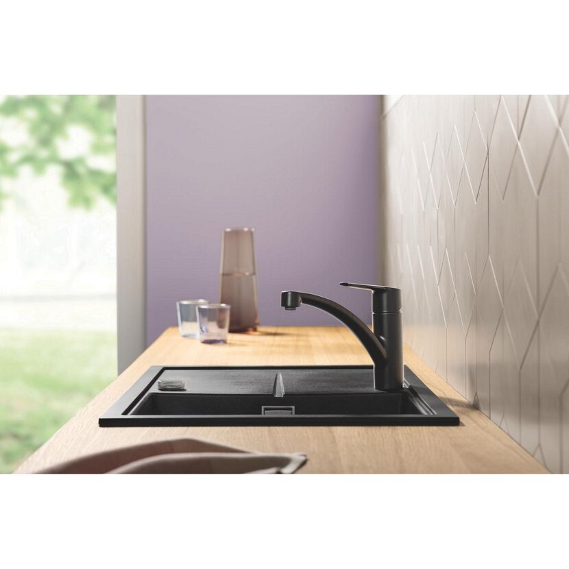 Schwarze Küchenspüle mit schwarzem Wasserhahn.