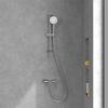 Duschkopf mit Schlauch und Armatur an einer grauen Wand.