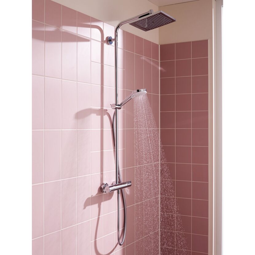 Duschsystem mit laufendem Wasser an rosa gefliester Wand