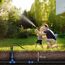 Vater und Kind spielen mit Gartenschlauch und unterirdischer HDPE-Rohrleitung
