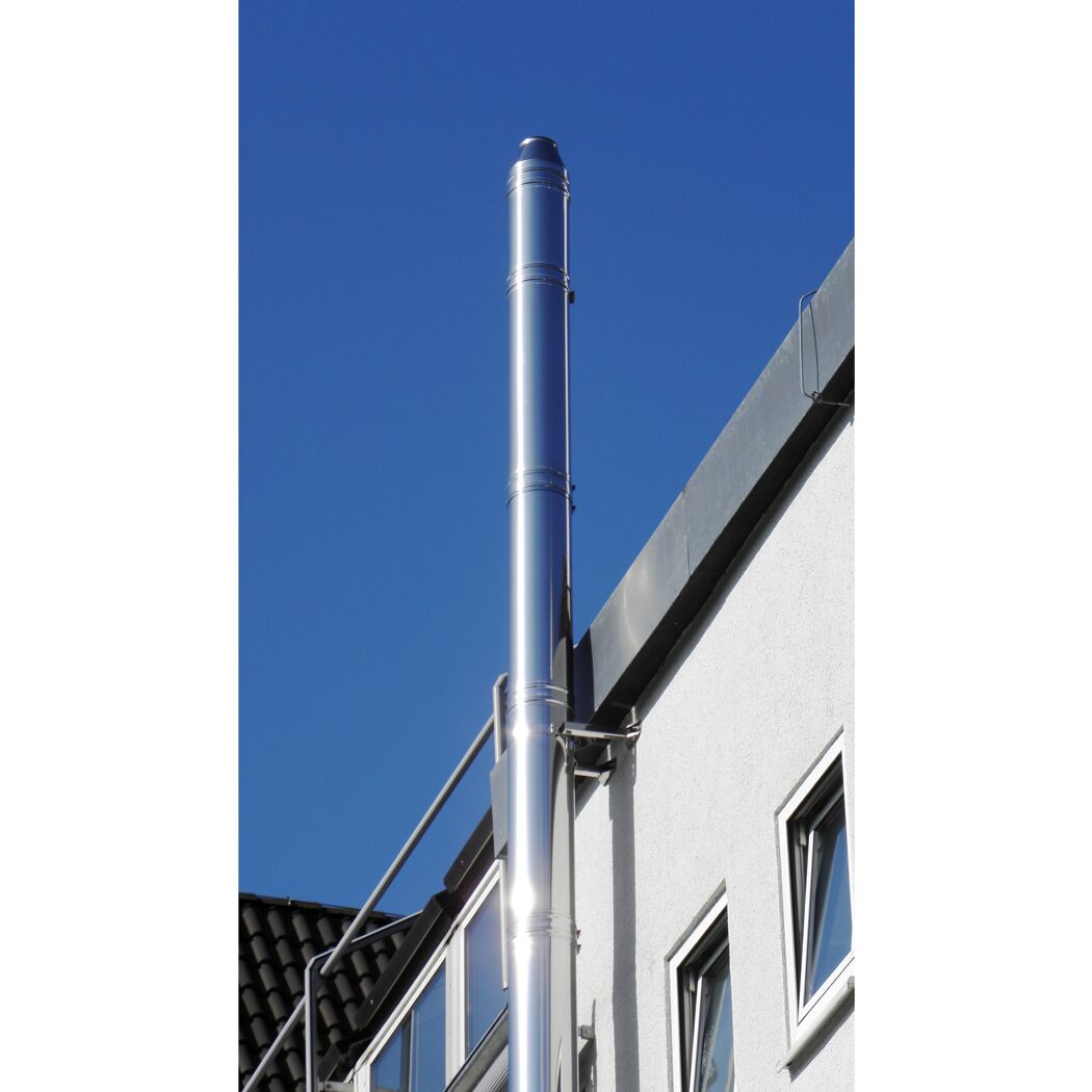 Glänzender Edelstahlkamin an Hauswand