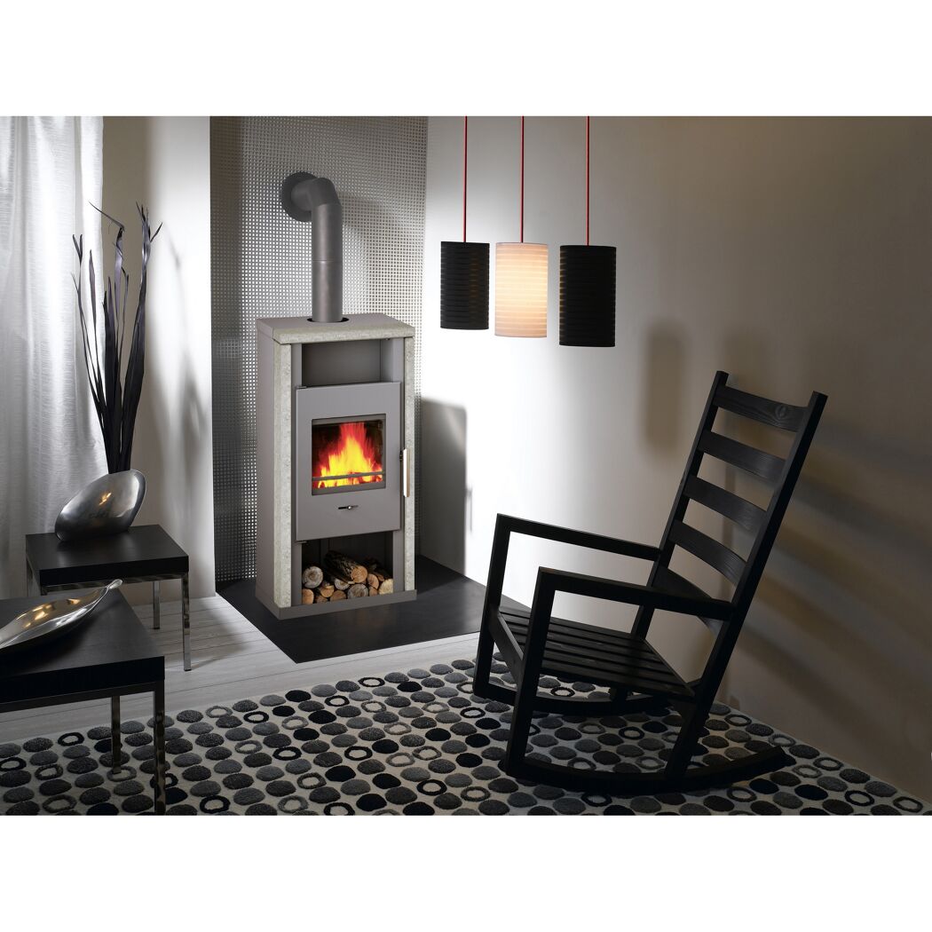 Kaminofen Yuna mit Natursteinrahmen und Feuer im Wohnzimmer.