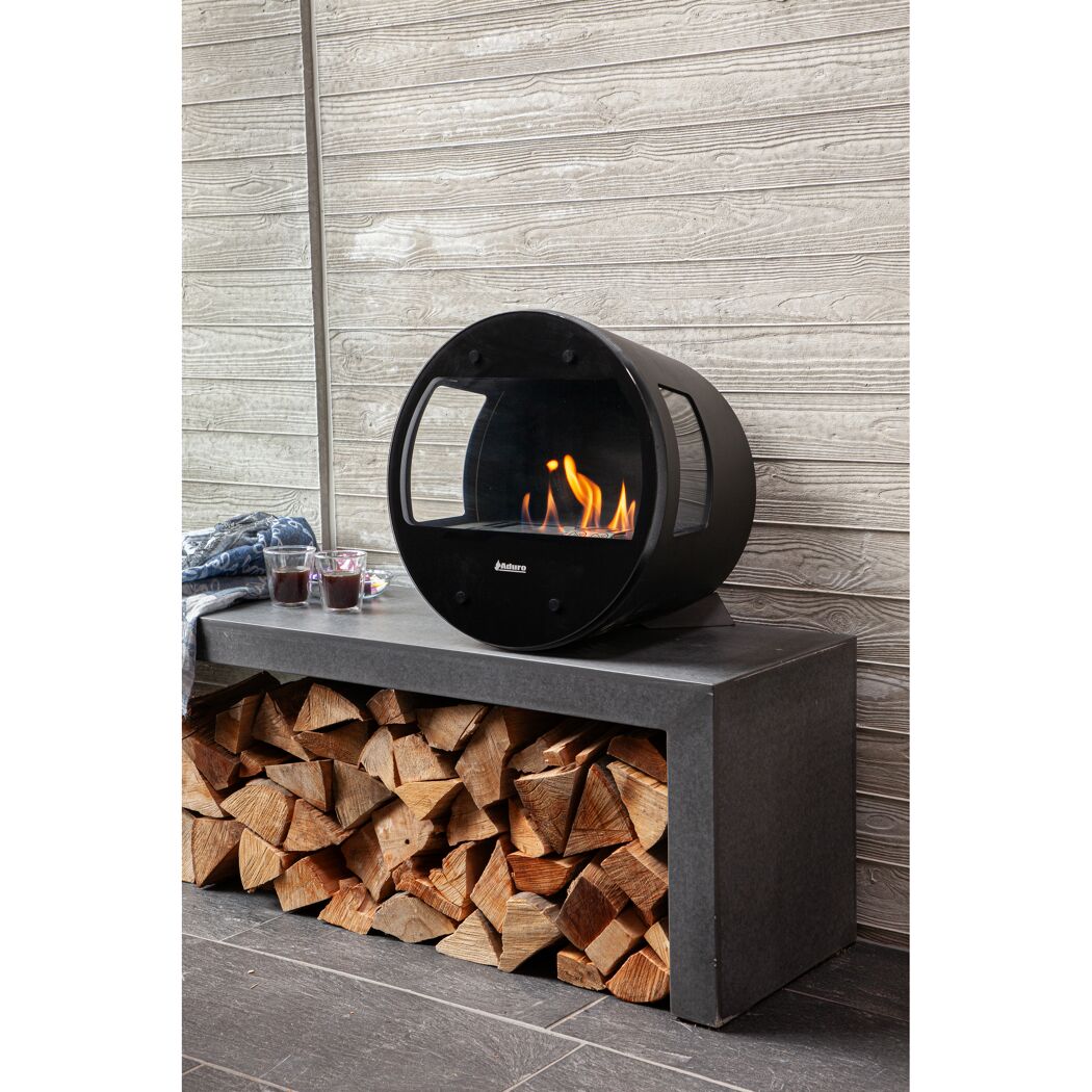 Runder Ethanolkamin auf Bank mit Holz