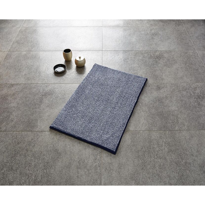Blauer Teppich "Fresh" auf grauem Fliesenboden.