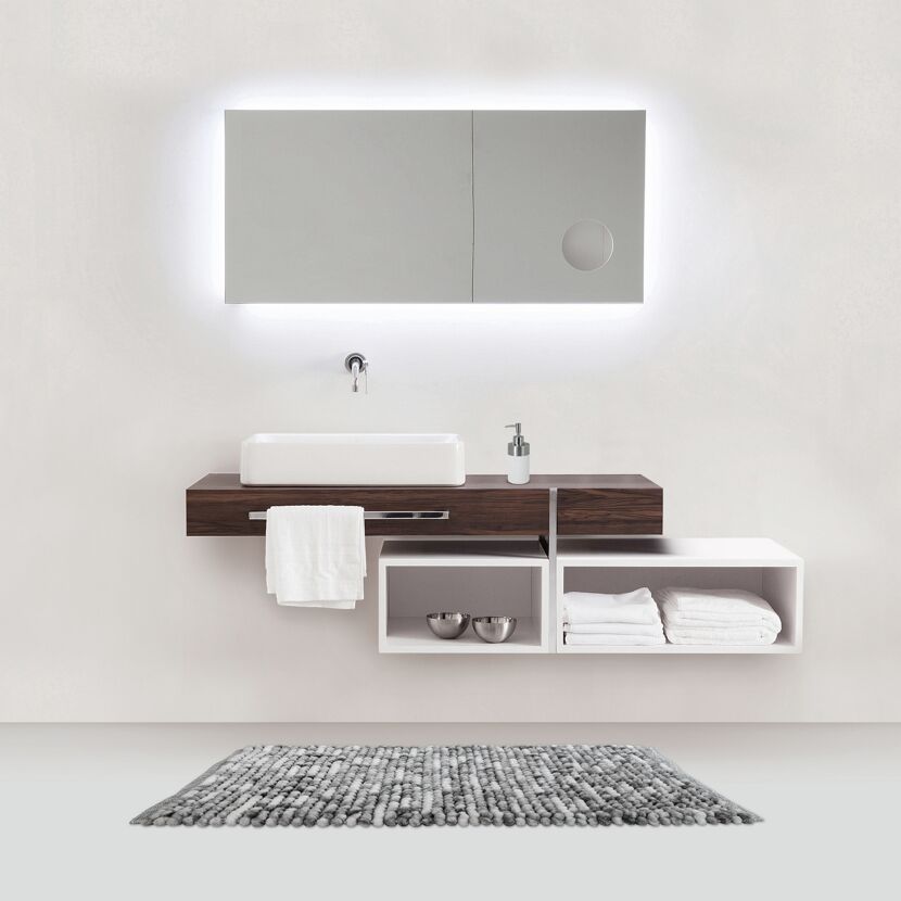 Modernes Badezimmer mit Waschbecken, Spiegel und Handtüchern.