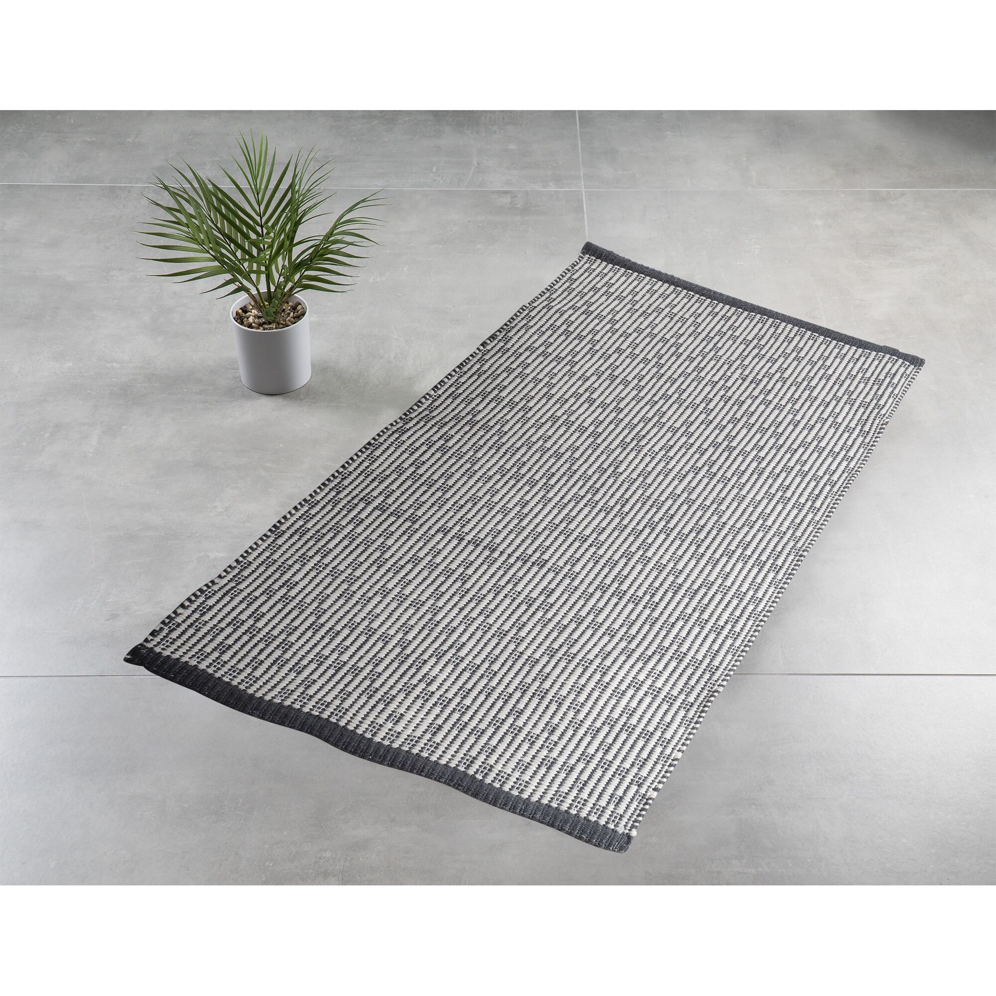 Grauer Badteppich Gaia auf grauem Fliesenboden