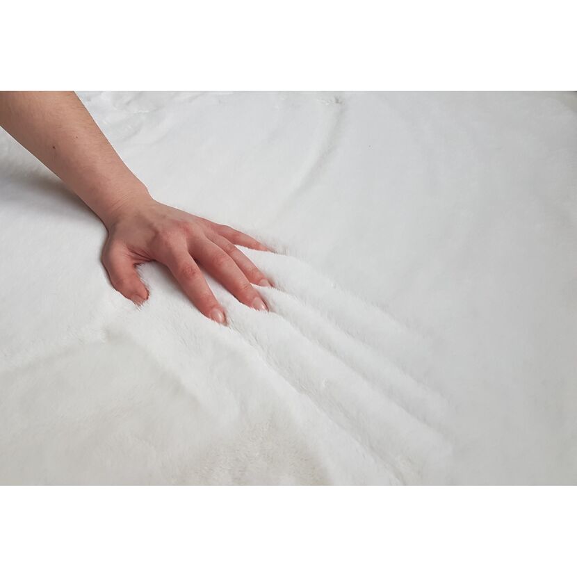 Hand berührt weißen Kunstfell-Teppich