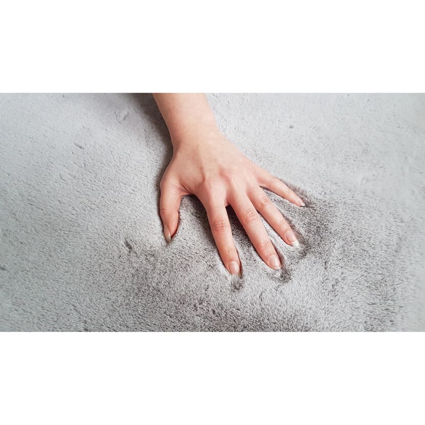 Hand streichelt grauen Teppich