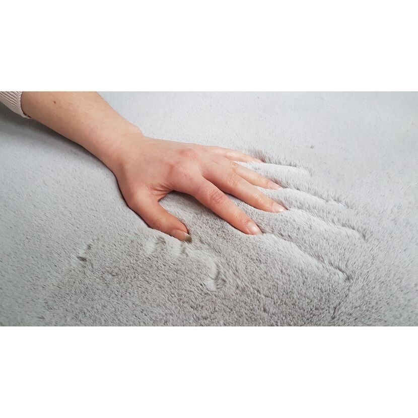 Hand auf grauem Fellteppich