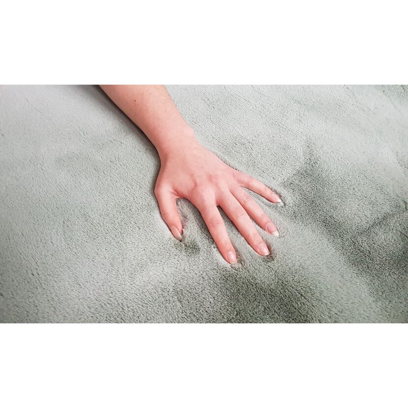 Hand berührt mintgrünen Teppich