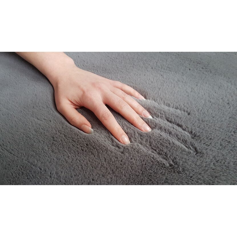 Hand streichelt grauen Hochflor-Teppich