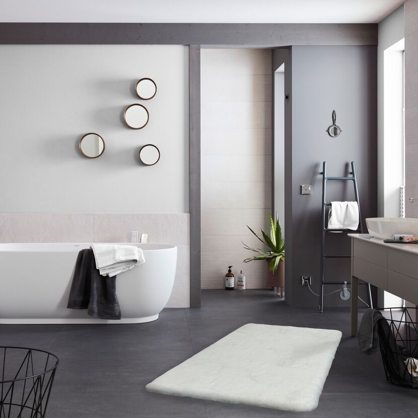 Weißer Badezimmerteppich vor Badewanne