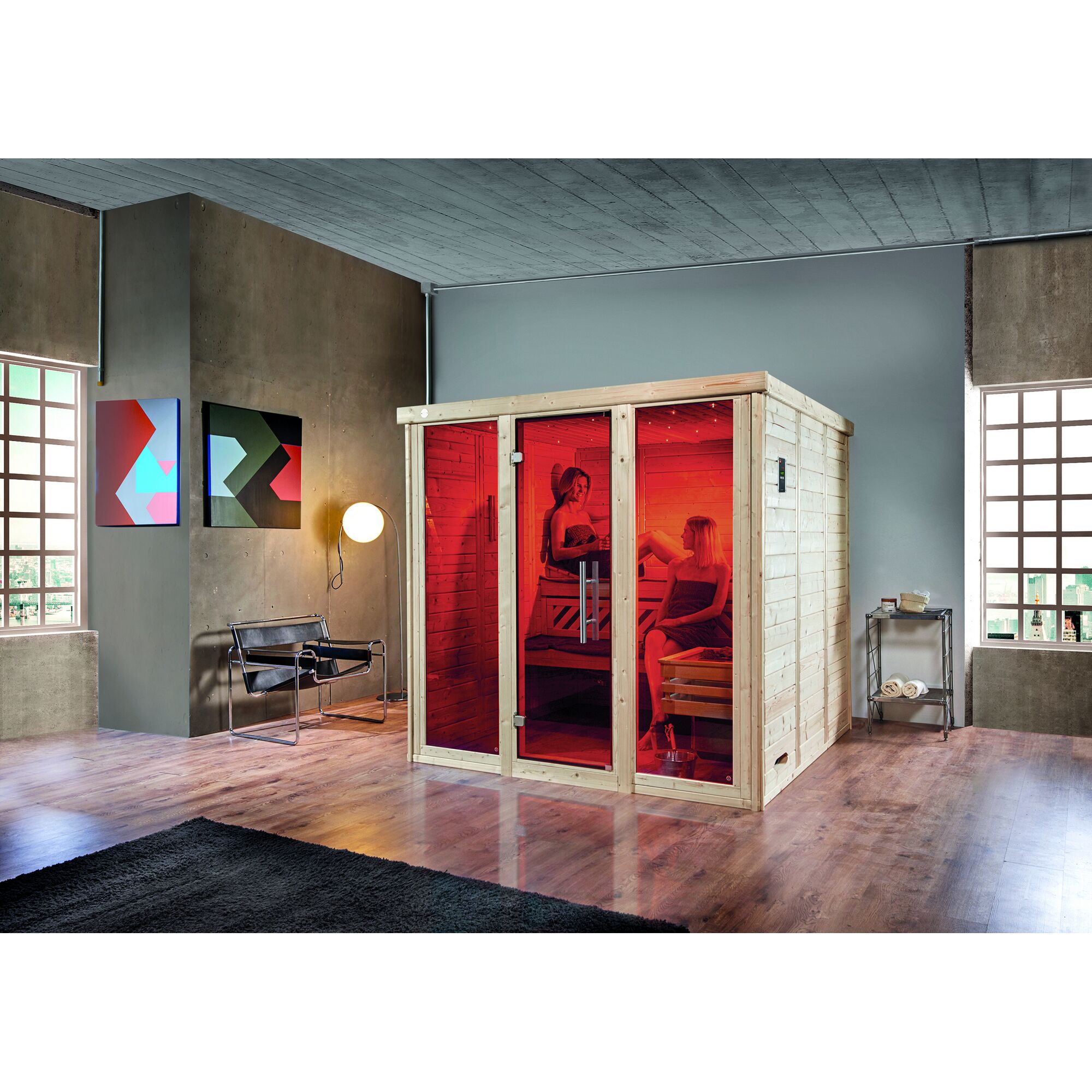 Zwei Personen entspannen in einer Sauna mit roter Beleuchtung.