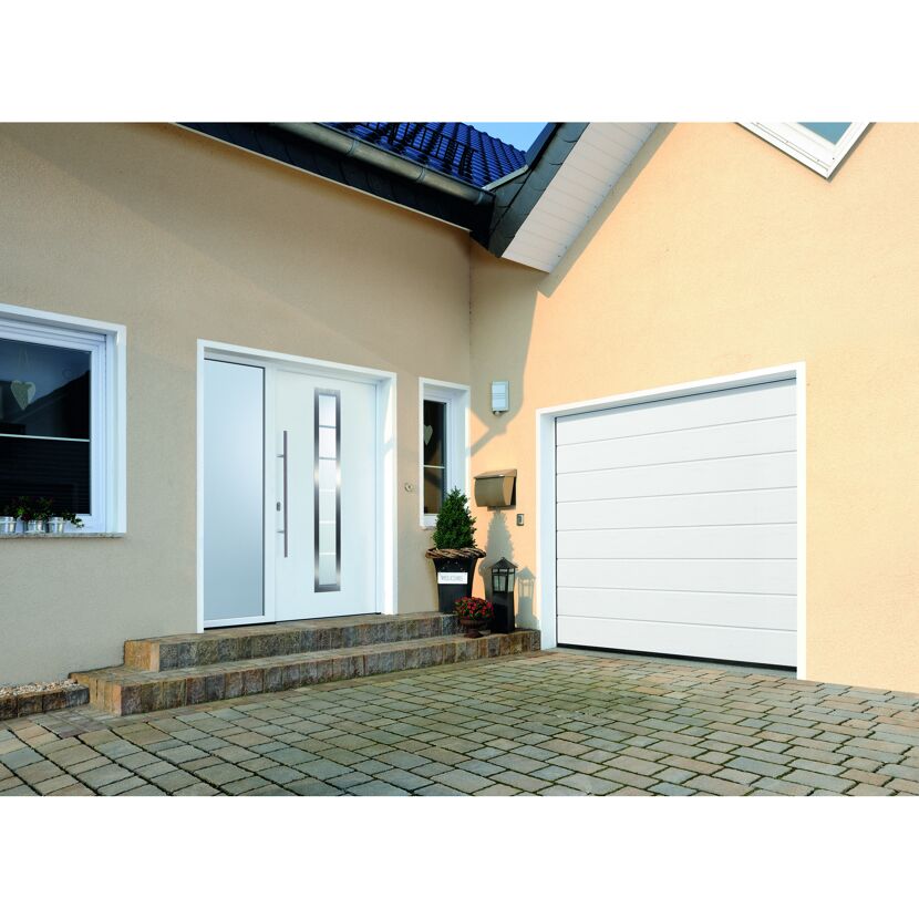 Weißes Garagentor und weiße Haustür an einem beigen Haus