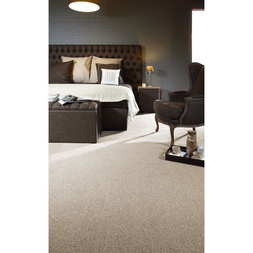 Beiges Schlafzimmer mit Bett, Sessel und Teppich