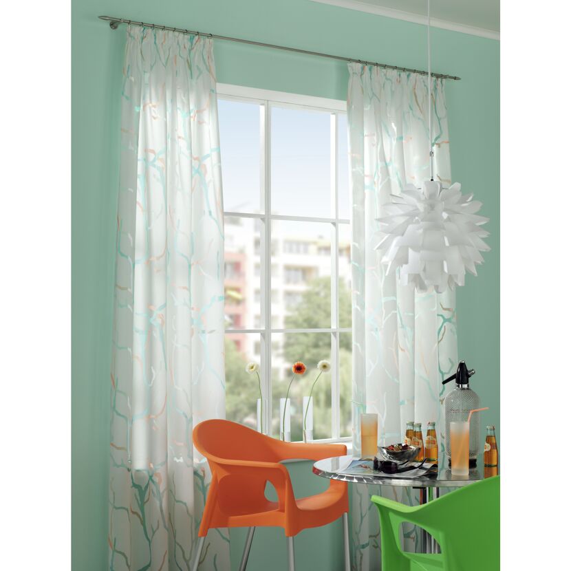 Wohnzimmer mit gemusterten Gardinen und moderner Einrichtung