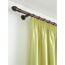 Grüne Gardine mit Raffhalter an bronzefarbener Gardinenstange