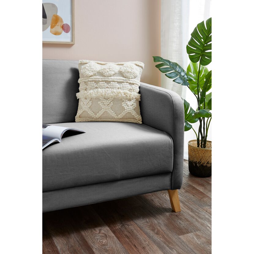 Beiges Kissen Inessa auf grauem Sofa