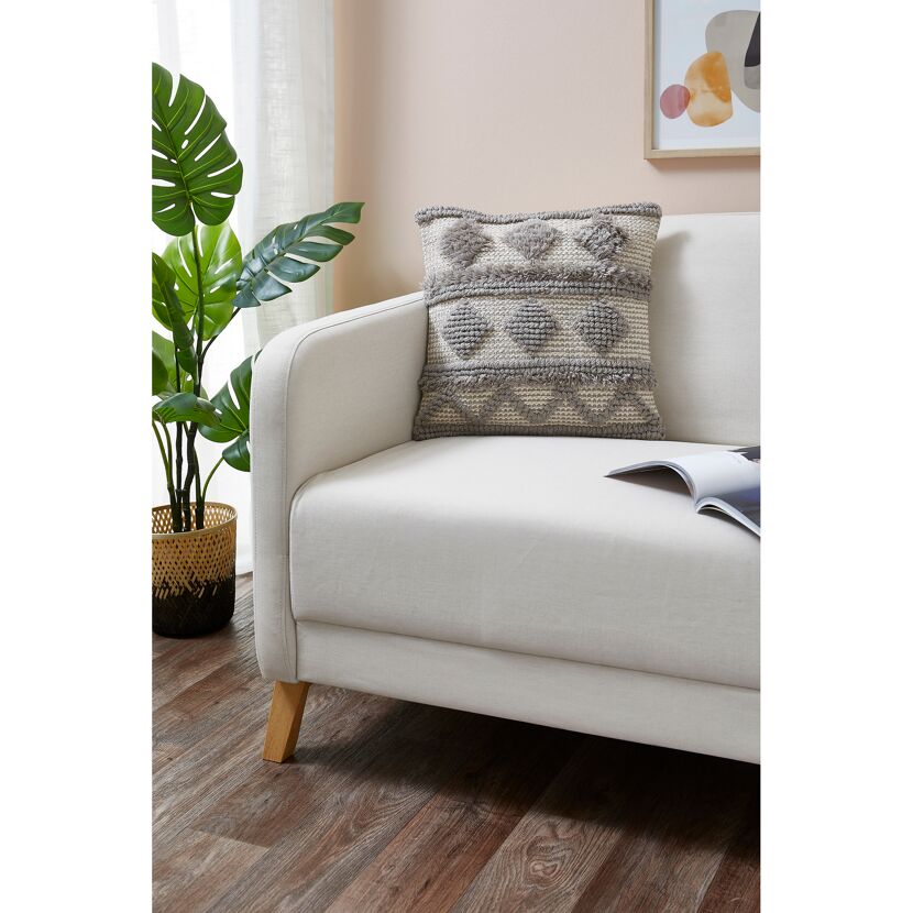 Graues Kissen Inessa auf einem Sofa