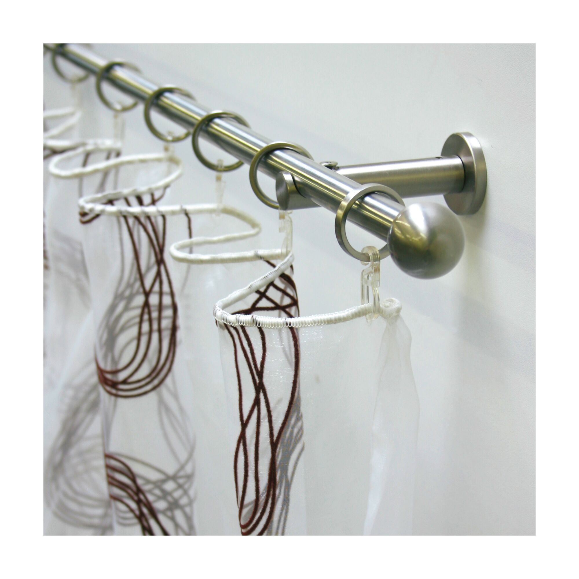 Weiße Gardinen mit braunem Muster an einer Edelstahl-Stilgarnitur.