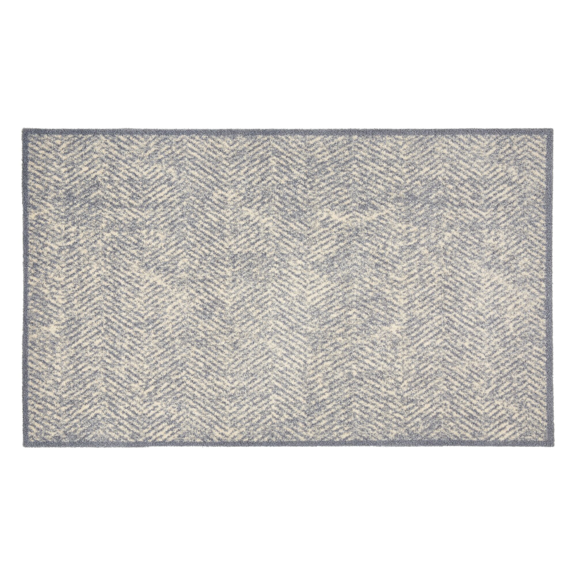 Blau-beiger Teppich mit Fischgrätmuster.