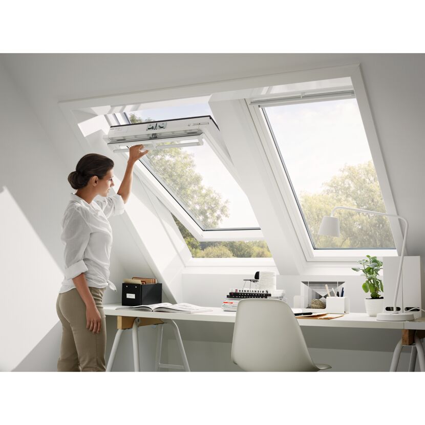 Person öffnet Dachfenster in einem Büro.