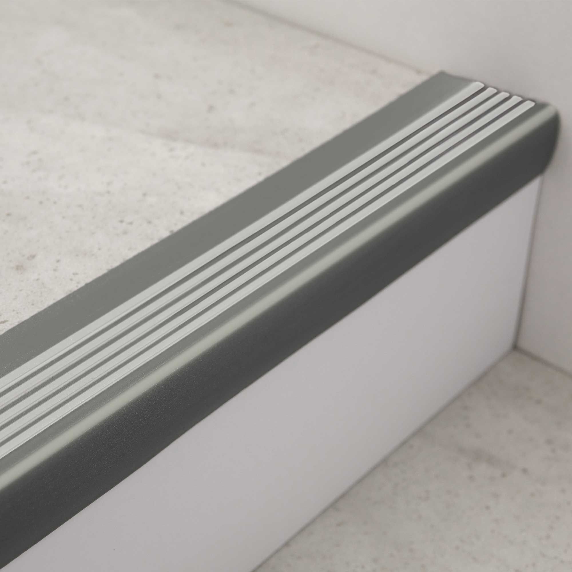 Graue Treppenkante mit silbernen Anti-Rutsch-Streifen