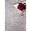 Beiger Hochflor-Teppich, daneben ein Tablett mit Rose und Blüten
