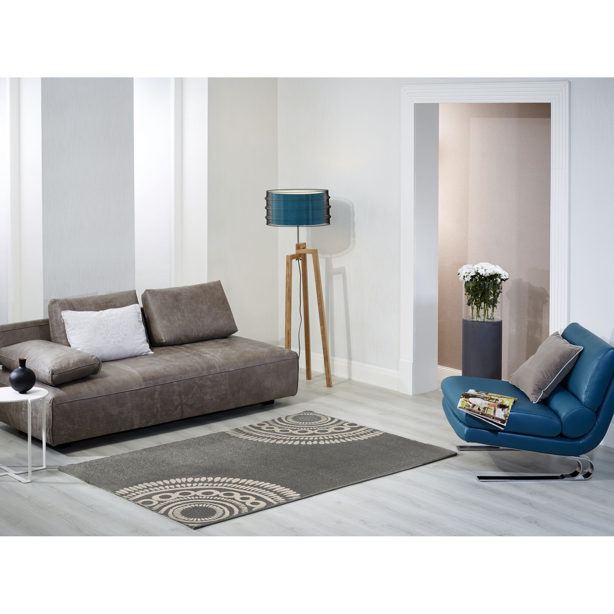 Wohnzimmer mit grauem Teppich, braunem Sofa und blauem Sessel