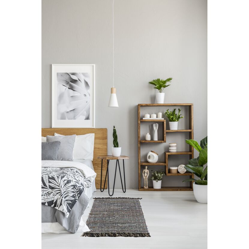 Schlafzimmer mit Bett, Holzmöbeln und Pflanzen.