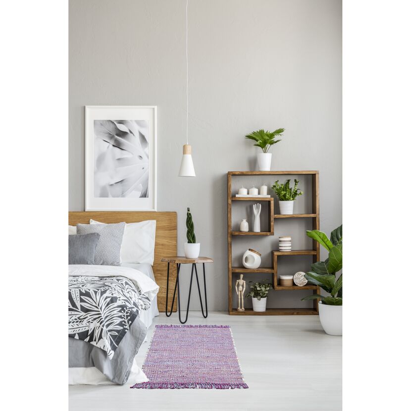 Schlafzimmer mit Bett, Beistelltisch, Regal und Teppich
