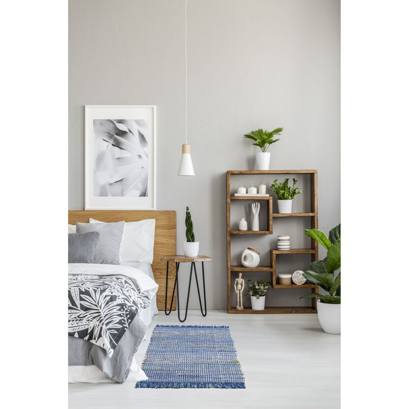 Schlafzimmer mit blauem Teppich und Holzmöbeln.