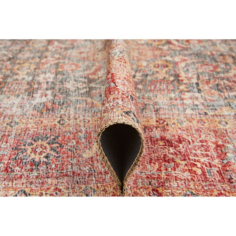 Aufgerollter Teppich in Rot-, Beige- und Grautönen