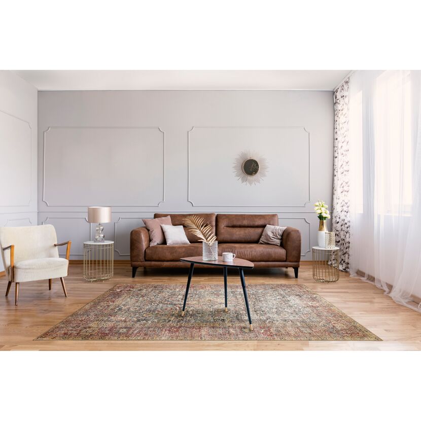Wohnzimmer mit braunem Ledersofa, Beistelltischen und hellem Sessel