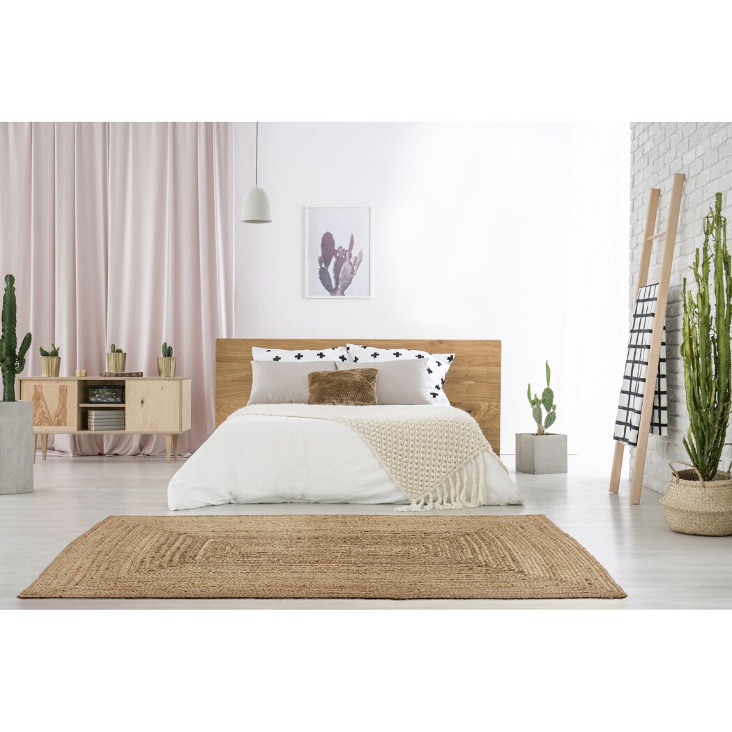 Schlafzimmer mit Juteteppich, Bett und Holzmöbeln