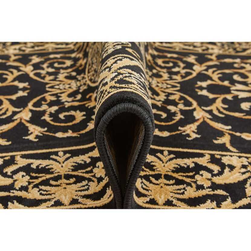 Nahaufnahme eines schwarzen Teppichs mit goldenen Ornamenten.