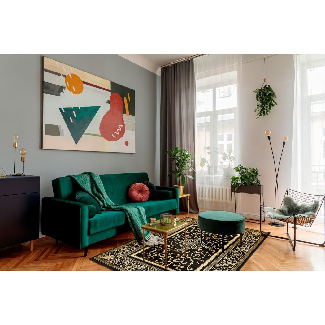 Wohnzimmer mit schwarzem Teppich und grünem Sofa