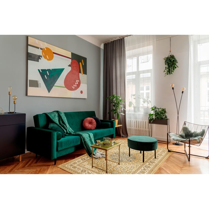 Wohnzimmer mit cremefarbenem Teppich, grünem Sofa und Sessel.
