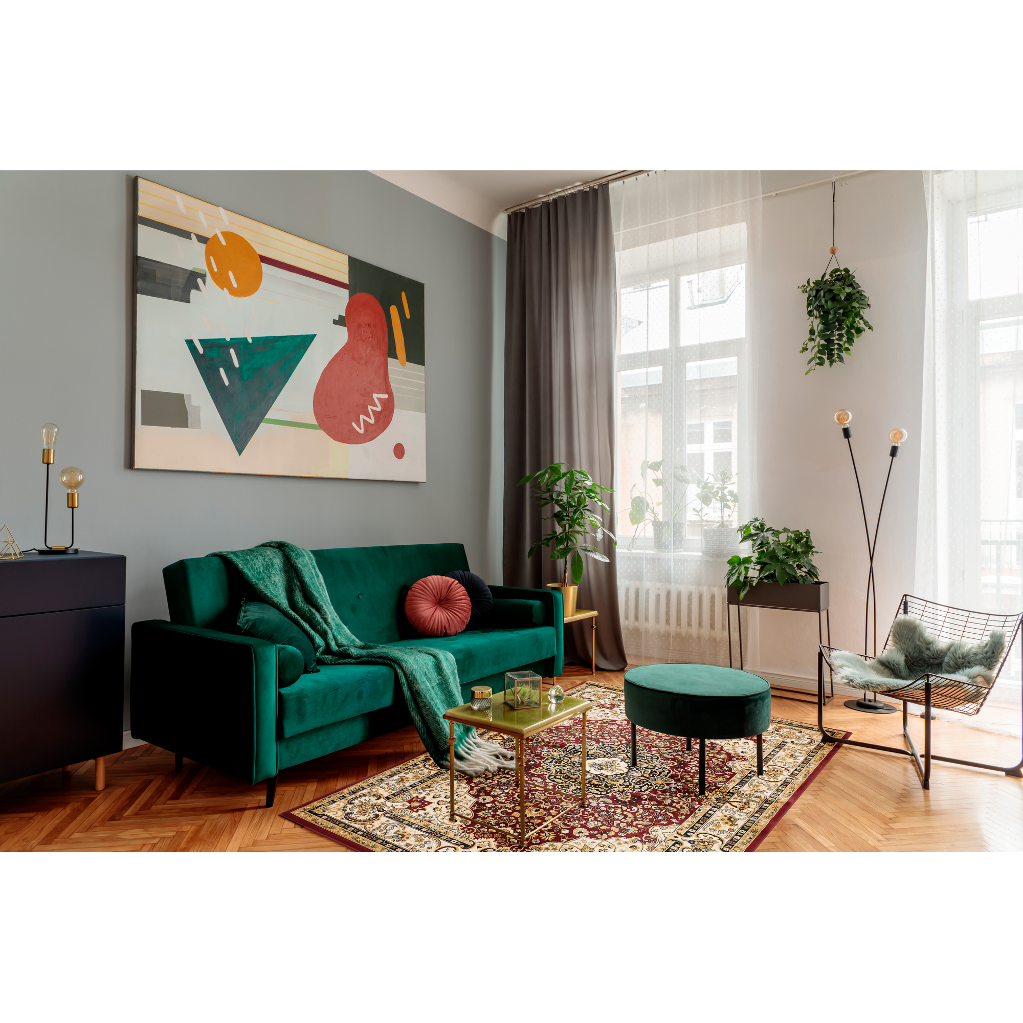 Wohnzimmer mit grünem Sofa, Teppich und Pflanzen