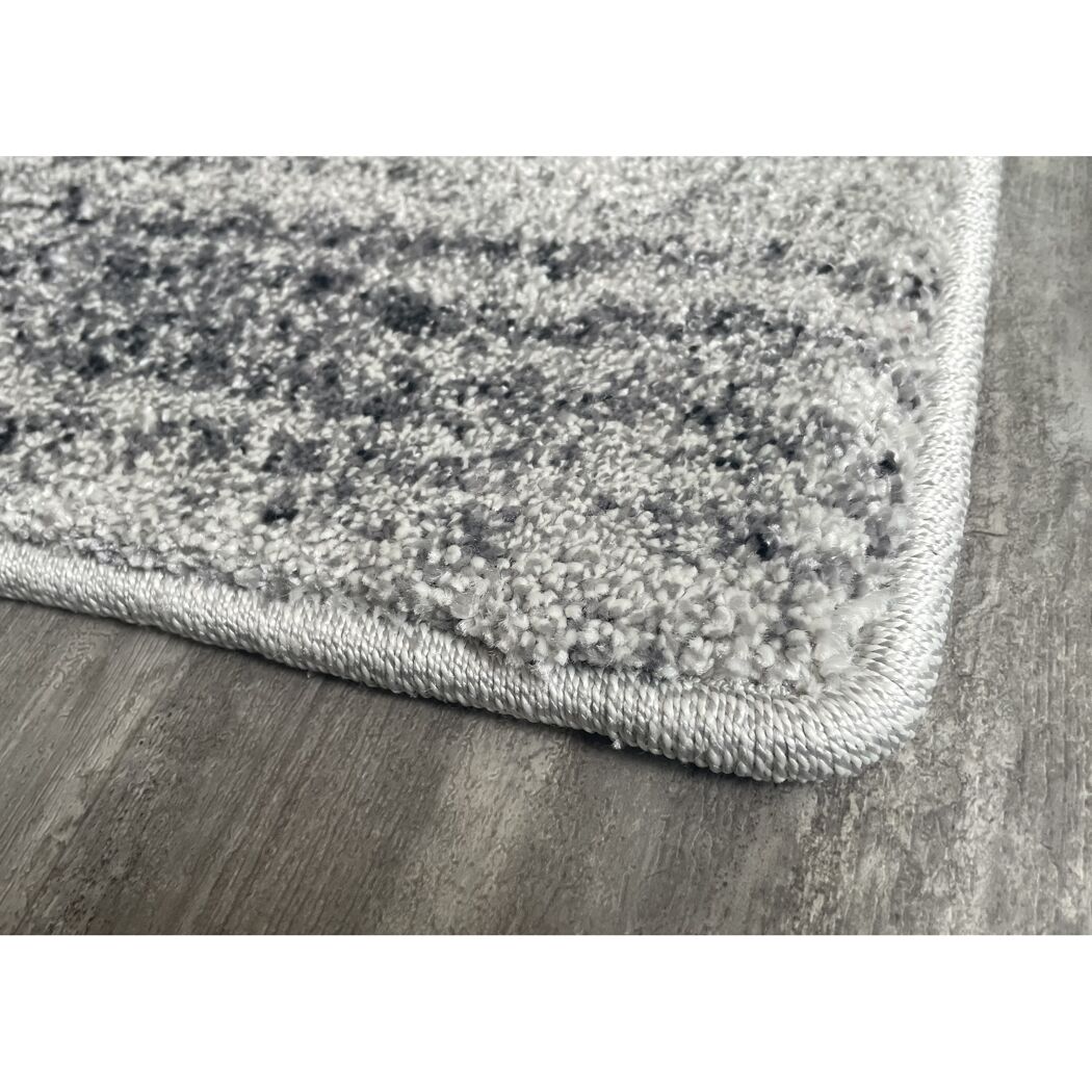 Ecke eines grauen Hochflor-Teppichs