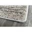 Ecke eines beige-braunen Teppichs