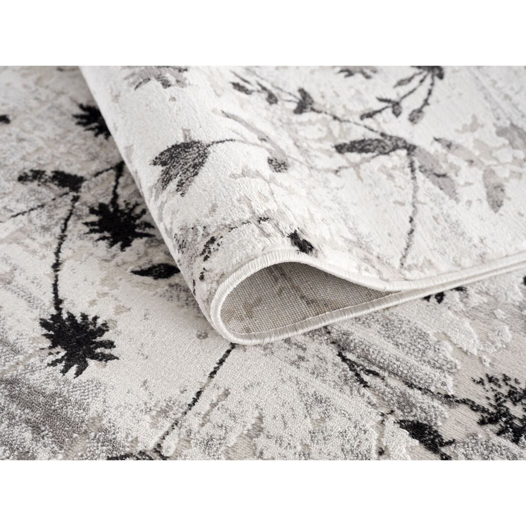 Beiger Teppich mit schwarzem Blumenmuster