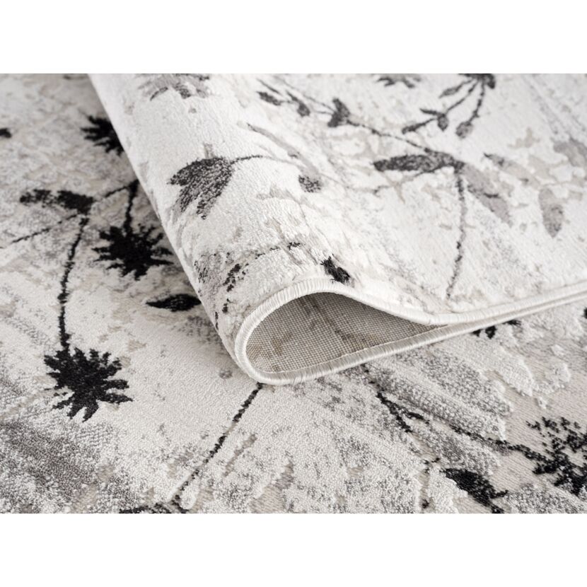 Beiger Teppich mit schwarzem Blumenmuster