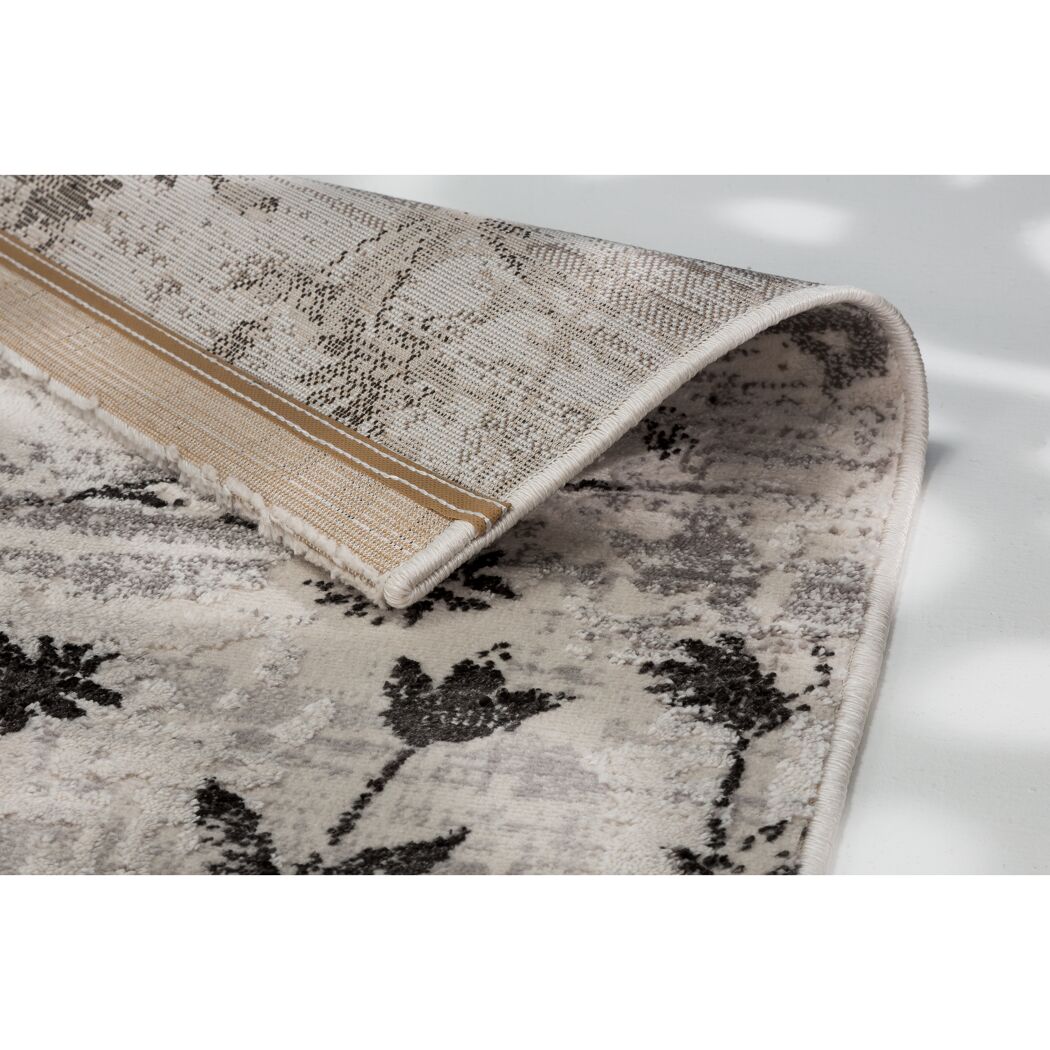 Beigefarbener Teppich mit schwarzem Blumenmuster