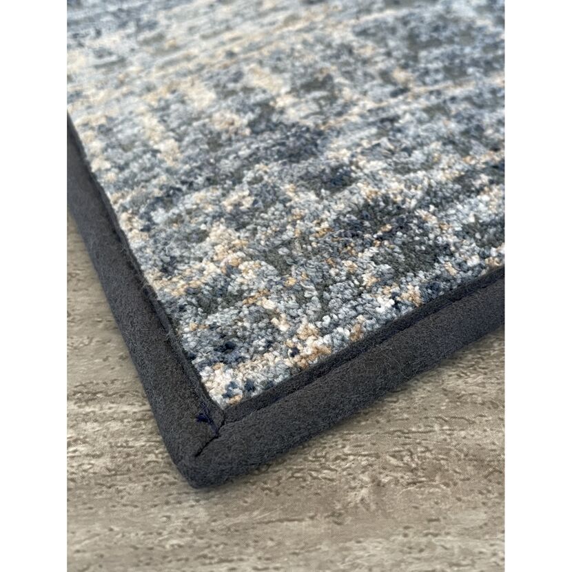 Ecke eines blau-beigen Teppichs