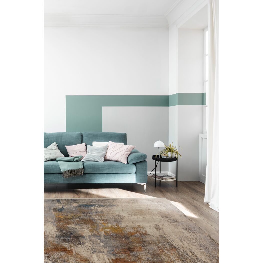 Grünes Sofa auf buntem Teppich