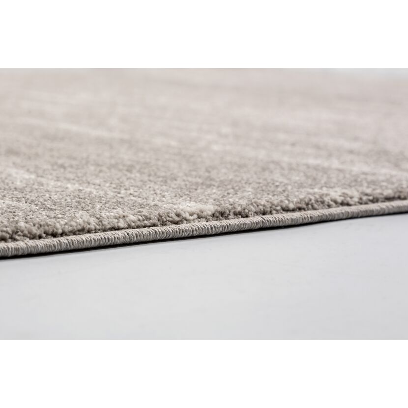 Beigefarbener Teppich mit sichtbarem Saum