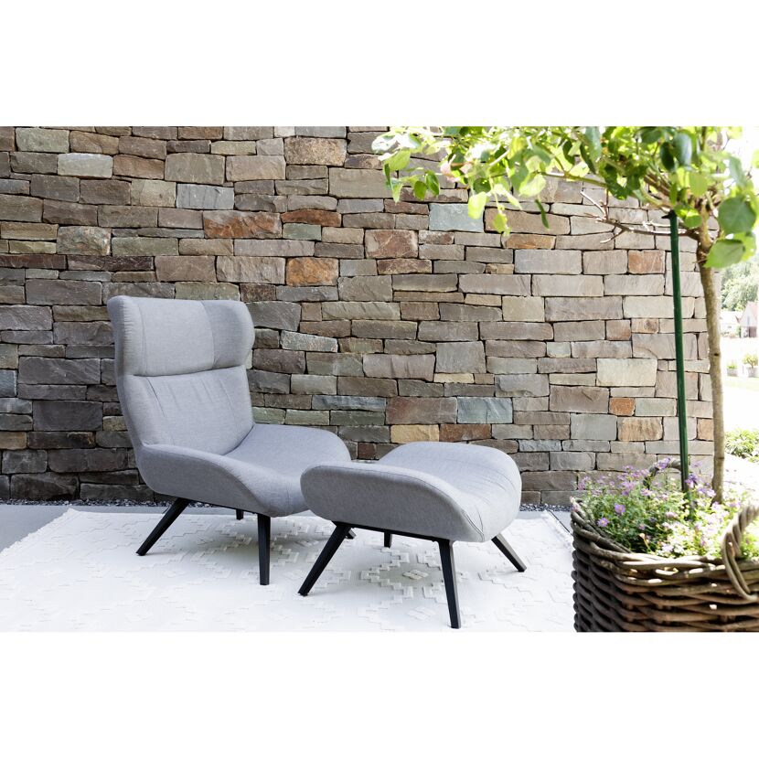 Grauer Sessel mit Fußhocker auf Terrasse